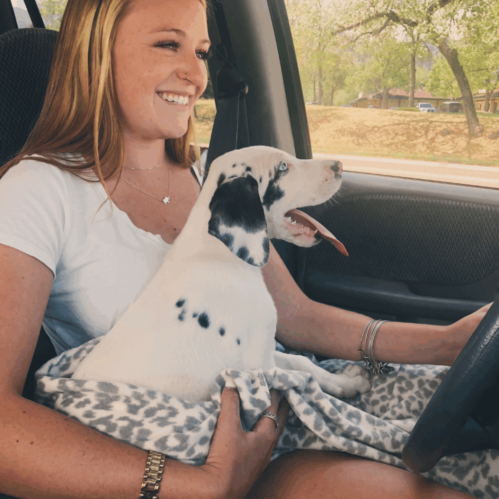 Haley smiling with baby Dymond on her lap in the car after picking him up
